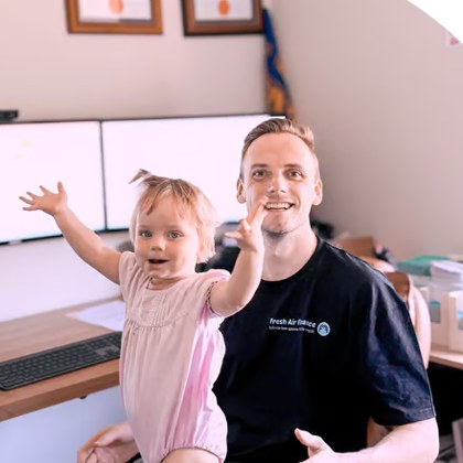 Rob Staff at his desk with his daughter Penny